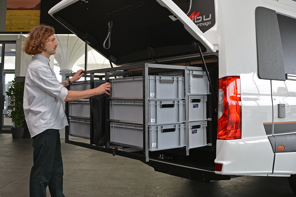 Redakteur begutachtet das Ordnungssystem in der Heckgarage des neuen Campervan Malibu Genius