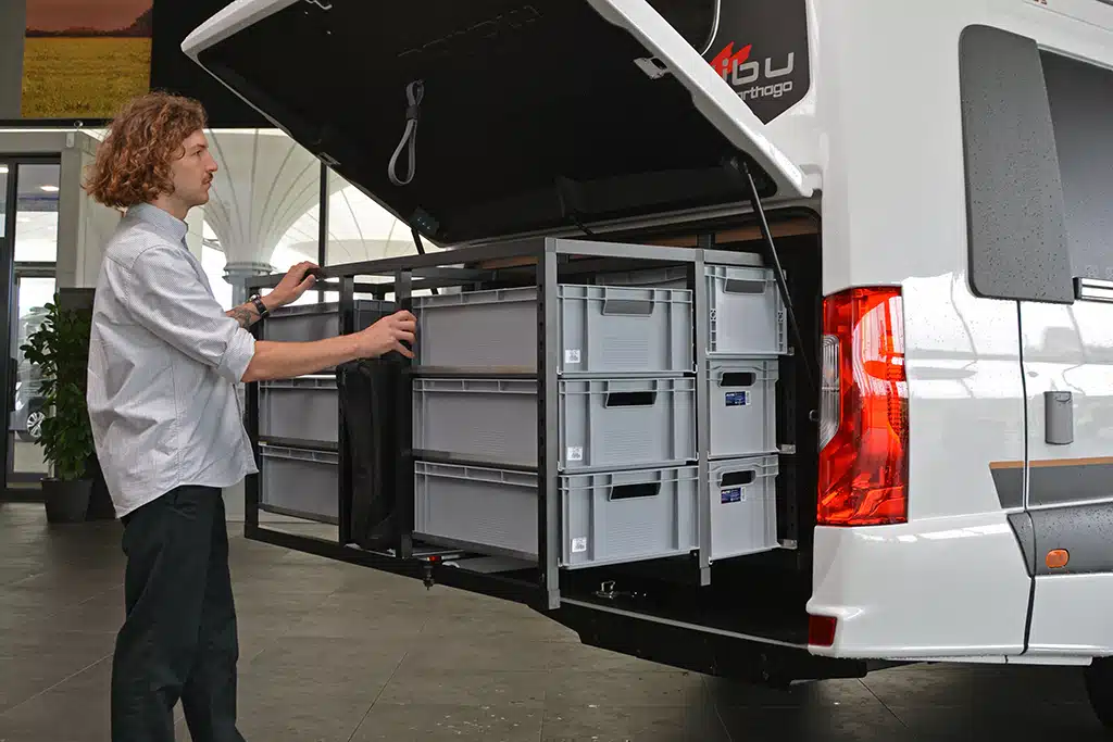 Redakteur begutachtet das Ordnungssystem in der Heckgarage des neuen Campervan Malibu Genius