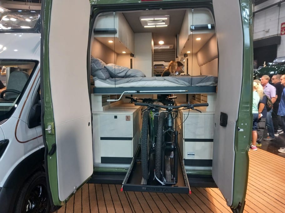 Heckansicht eines Campervans mit Hubbett und zwei Fahrrädern im Mittelgang