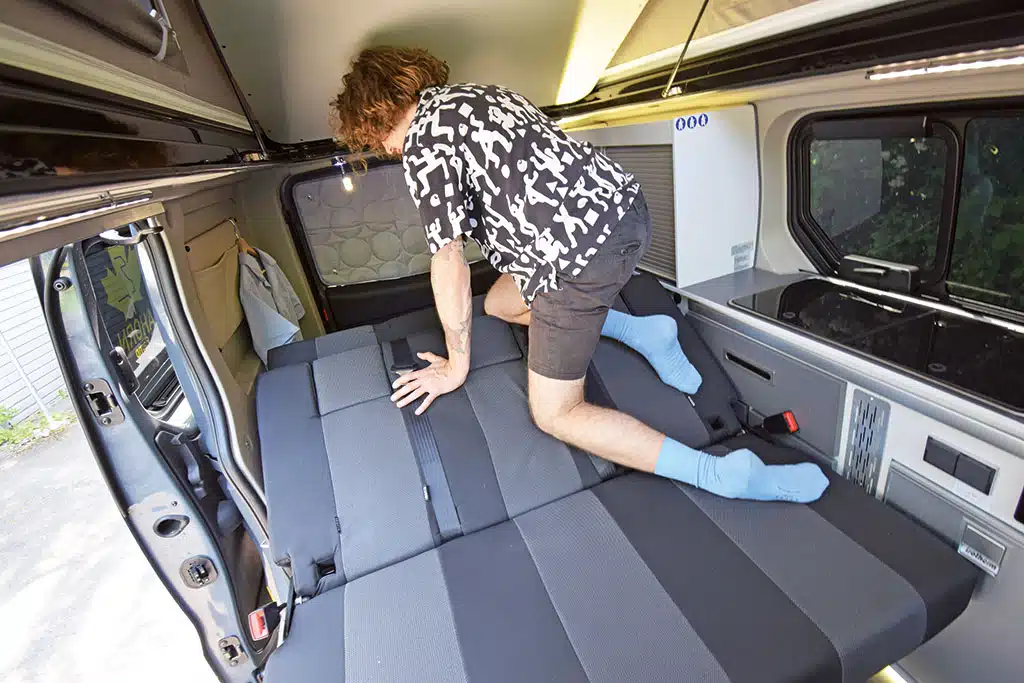 Der Autor klappt die Rücksitzbank im Campingbus um
