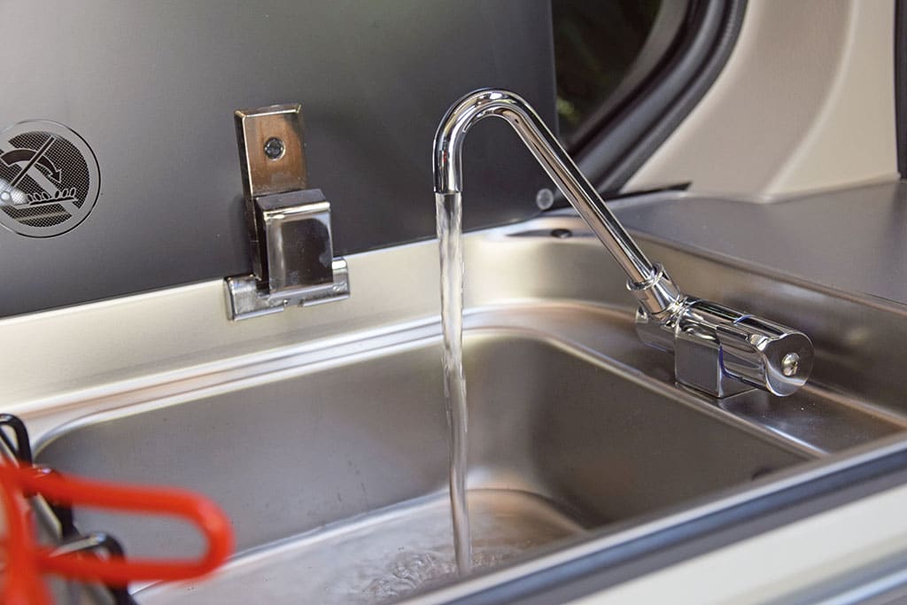Wasser läuft aus einem Wasserhahn in ein Spülbecken
