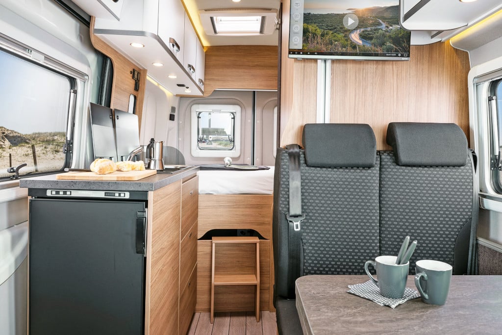 Graue Zweier-Sitzbank, beige-marmorierter Tisch und Küchenplatte, helles Möbeldekor.