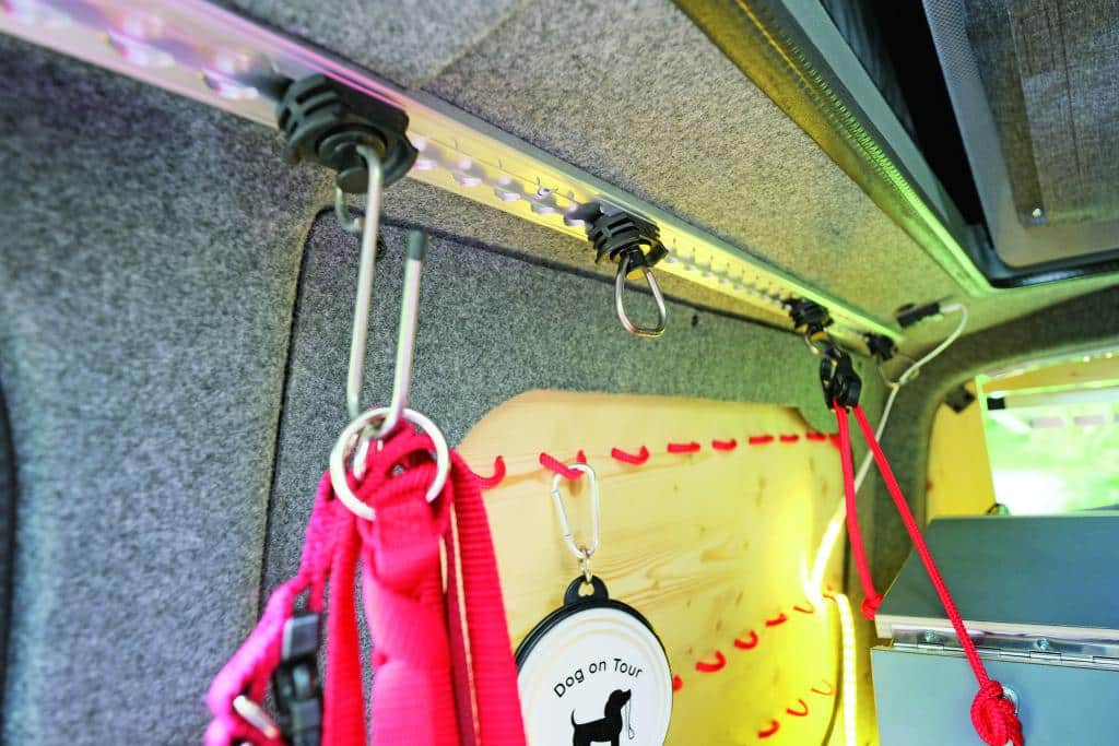 Metallschiene mit Haken zum Befestigen und Einhängen von Taschen und Equipment an der Filzwand im Campingbus