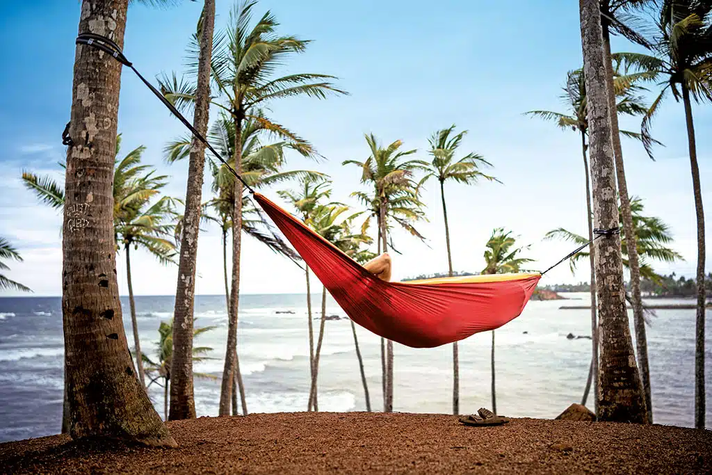 Rote Hängematte zwischen Palmen am Strand