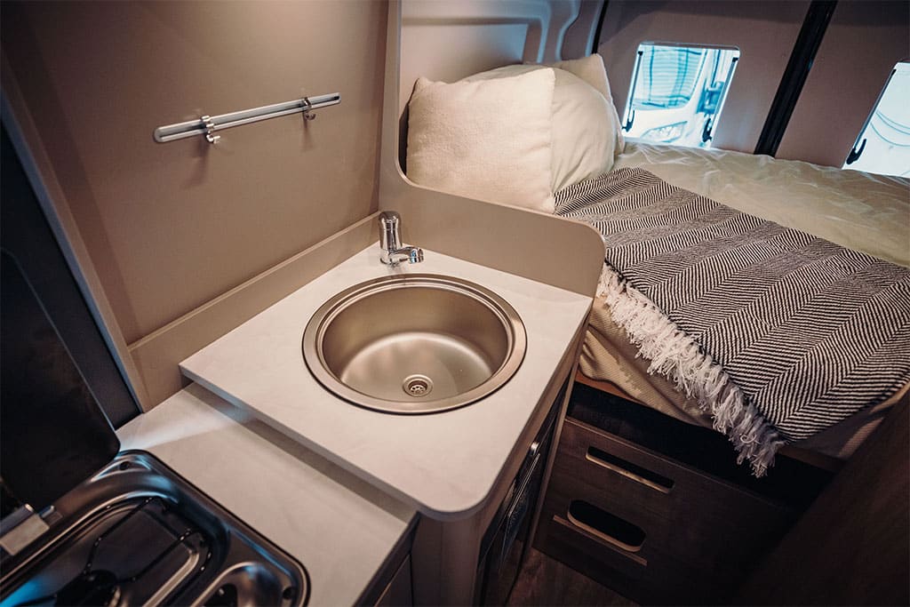 Innenansicht Waschbecken und Bett des Carado CV590 4x4 Campervans.