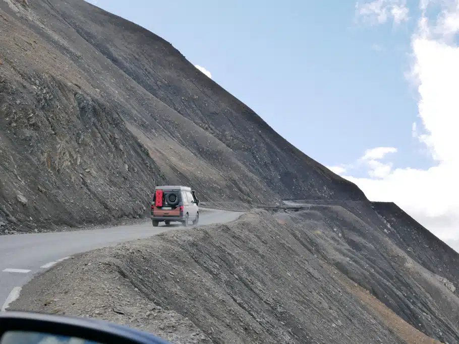 Ein Fahrzeug auf einer Bergstraße, der Berg ist steinig und ohne jedlichen Pflanzenbewuchs