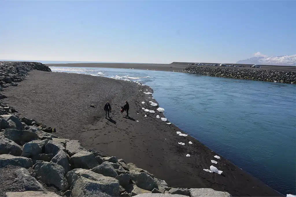 Glitzernde Eisbrocken auf schwarzen Sand, bekannt als Diamond Beach, an der Mündung der Gletscherlagune.