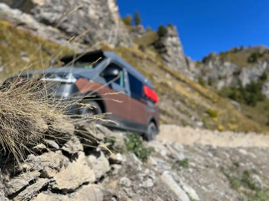 Grauer VW Bus in bergiger Landschaft
