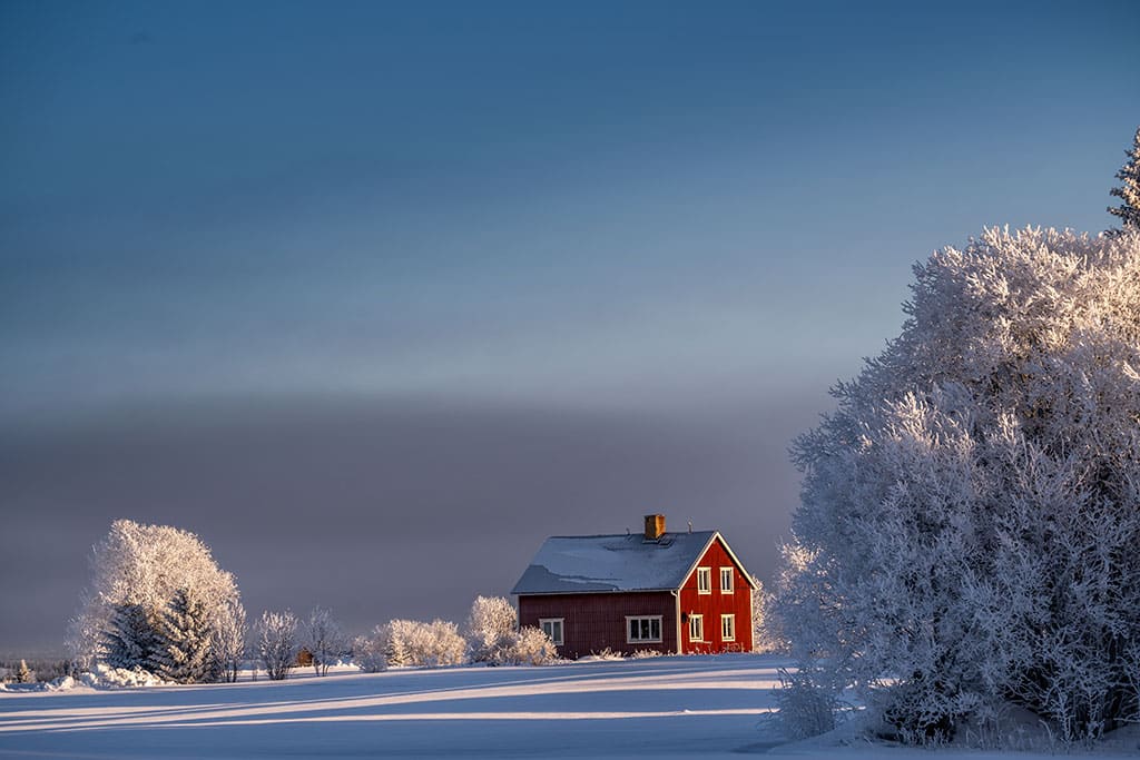 EIn rotes Haus inmitten schneebedeckter Landschaft