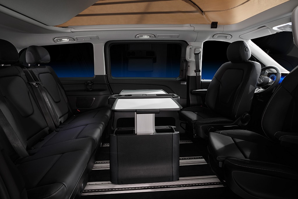 Fahrgastraum mit Klapptisch, Sitzbank und gedrehten Fahrerhaussitzen.