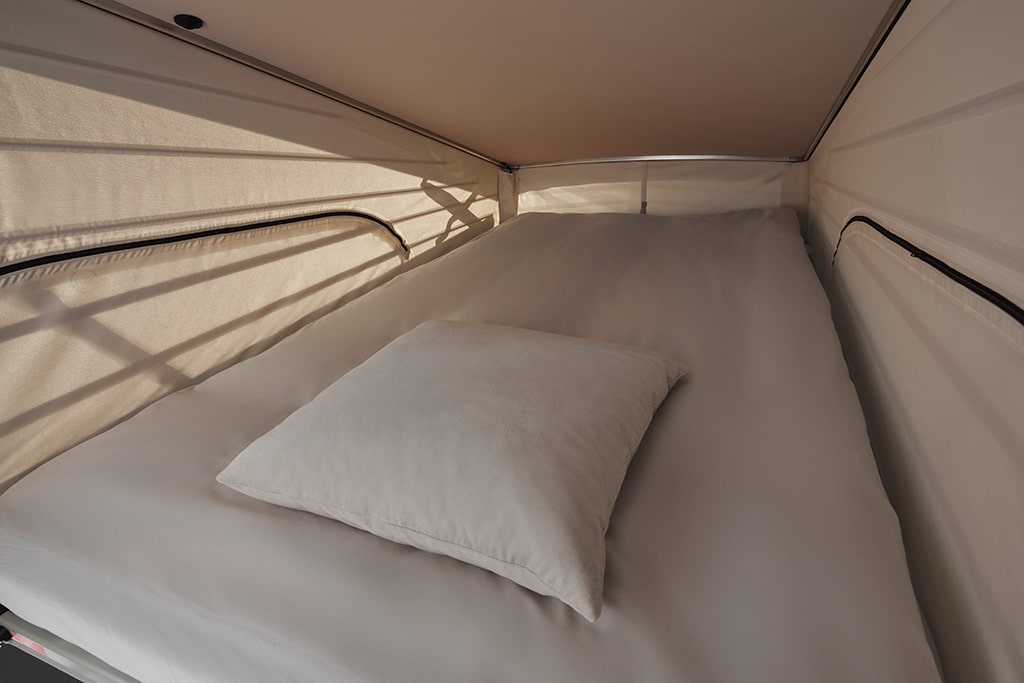 Bett im Aufstelldach eines Campingbus von Mercedes-Benz.