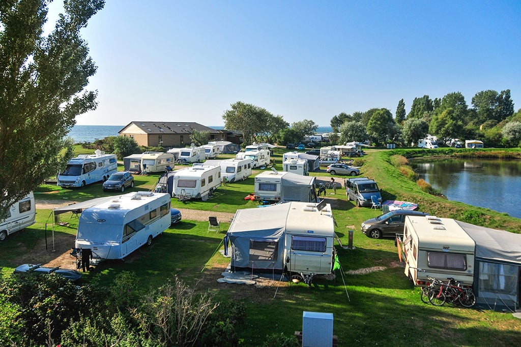 Stellplatz vom Campingplatz auf grüner Wiese mit Meerblick