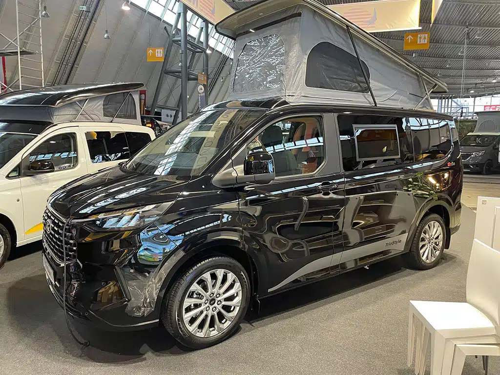 Schwarzer Campingbus mit Aufstelldach in Messehalle