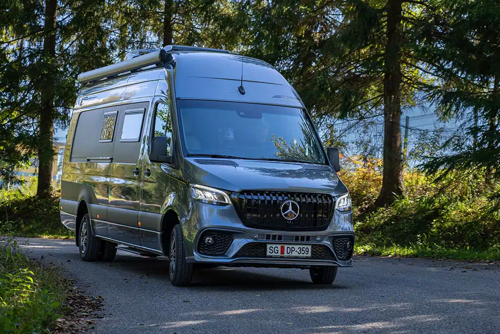 Dunkelgrauer Mercedes-Benz Sprinter mit Markise auf einer Landstraße