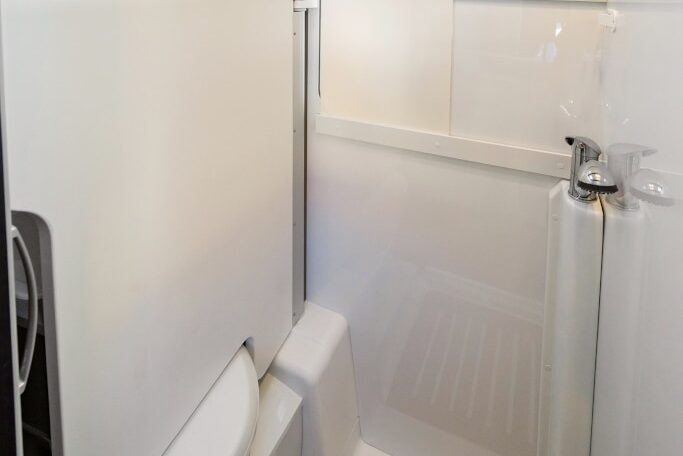 Die Wand mit dem Waschbecken ist über die Toilette geschwenkt und ergibt eine glatt Nasszelle