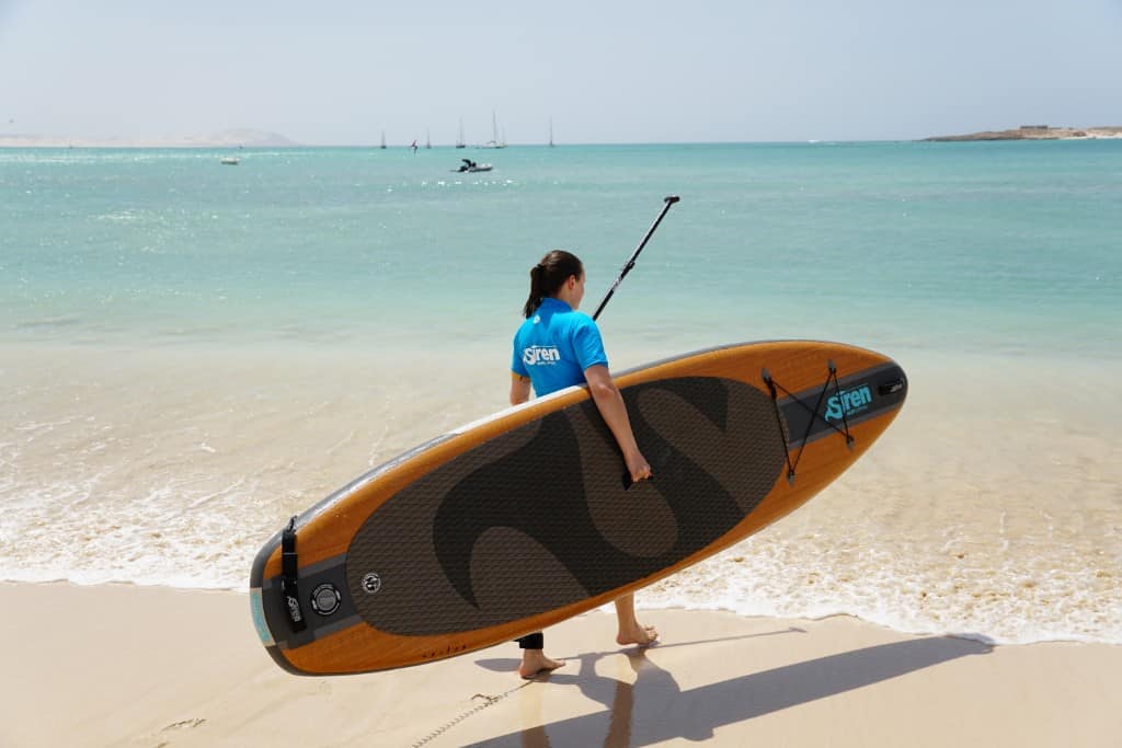 Wassersport-Zubehör: Frau am Wasser mit SUP-Board