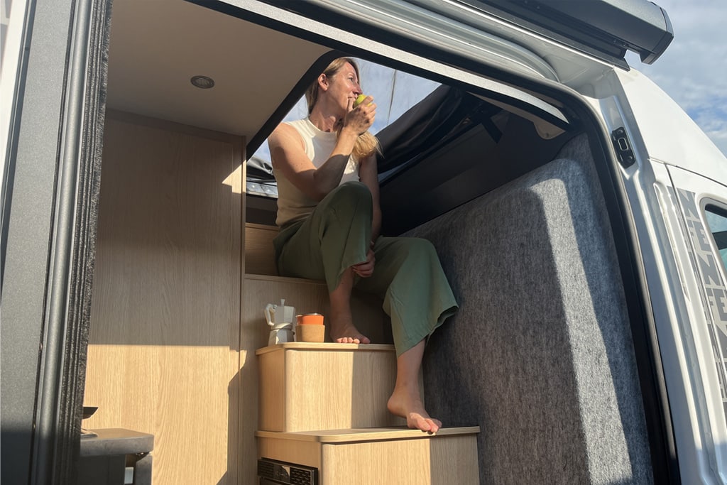 Frau sitzt auf der Treppe im Sunlight Cliff Vanlife