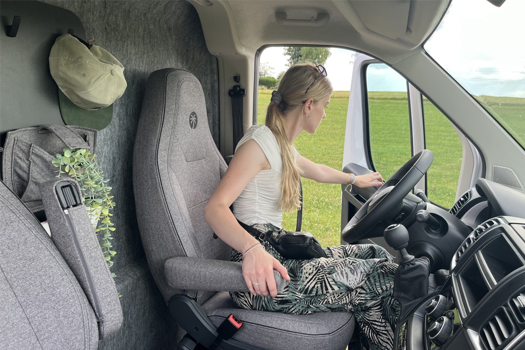 Frau sitzt auf dem Fahrersitz des Sunlight Cliff Vanlife Campervans