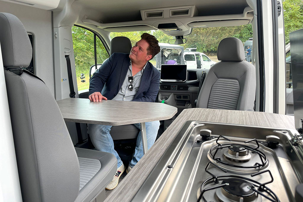 Redakteur sitzt auf gedrehtem Fahrersitz im Campervan