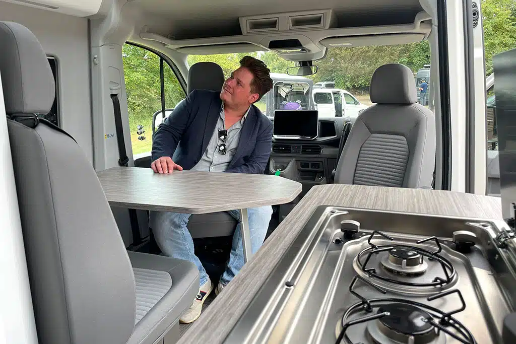 Redakteur sitzt auf gedrehtem Fahrersitz im Campervan