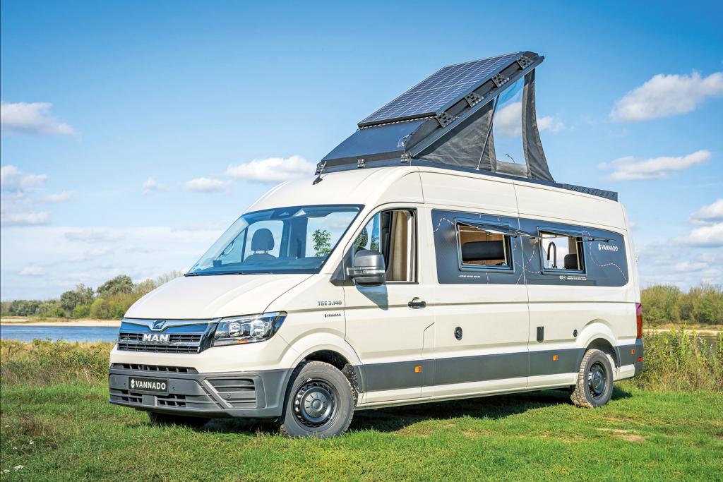 Weißer Campervan mit Aufstelldach auf einer Wiese