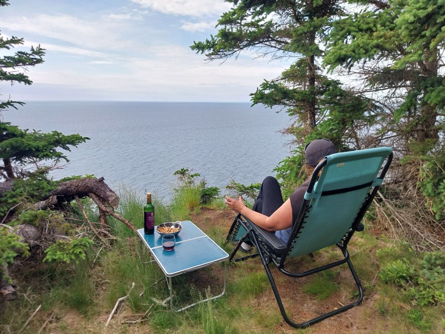 Frau auf Campingstuhl am See