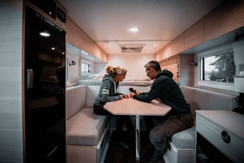 Mann und Frau sitzen sich im Camper gegenüber