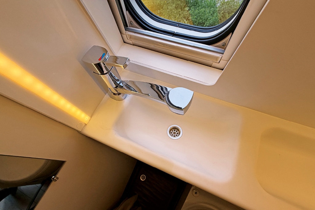 Schmales Waschbecken im Bad vor Fenster