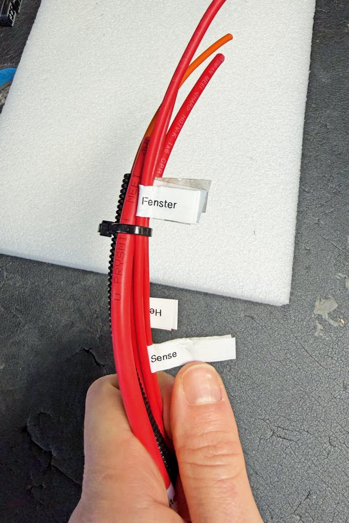 Rote Elektrokabel im Camperausbau mit Beschriftungen für Fenster und Sensorik