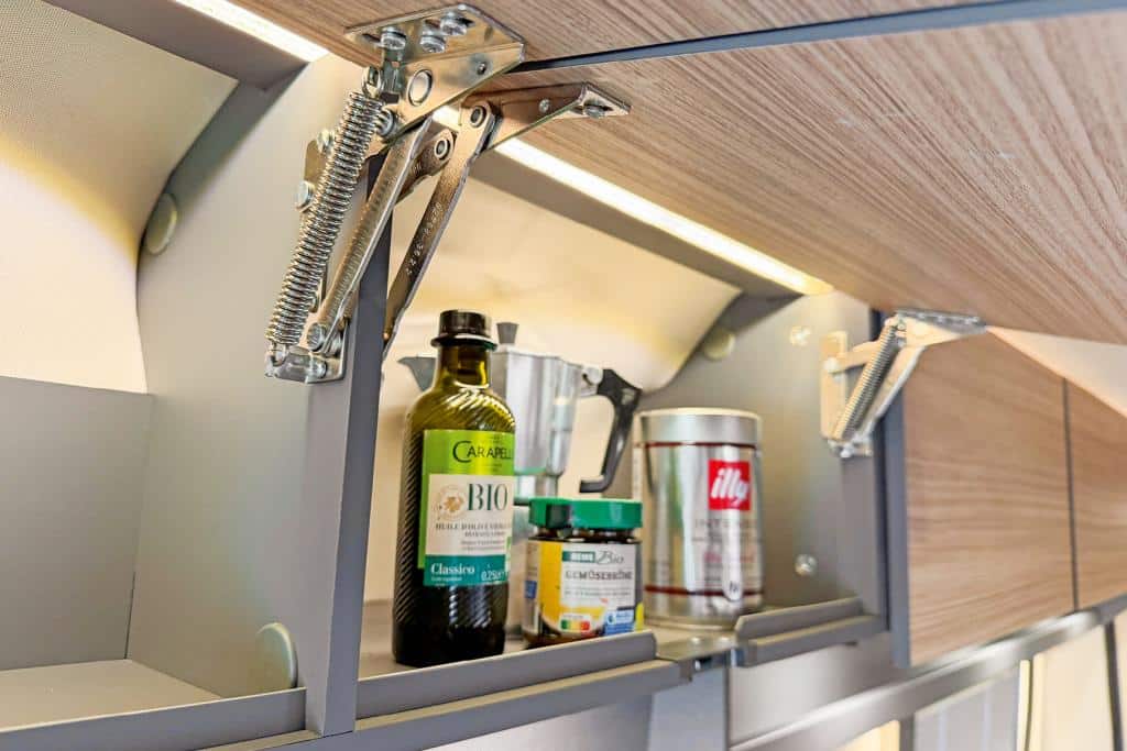 Geöffneter Schrank mit mehreren Flaschen und Pflegeprodukten.
